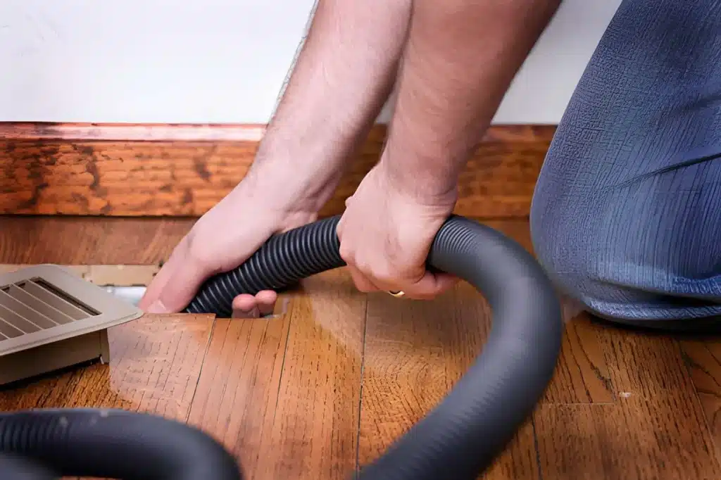 Professional Duct Cleaning technician cleaning residential air vents for improved indoor airflow.