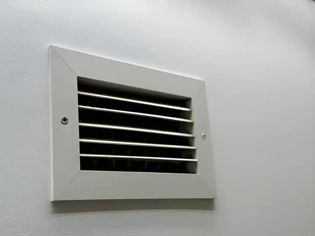 Technician performing AC Ventilation Cleaning to improve indoor airflow and system efficiency